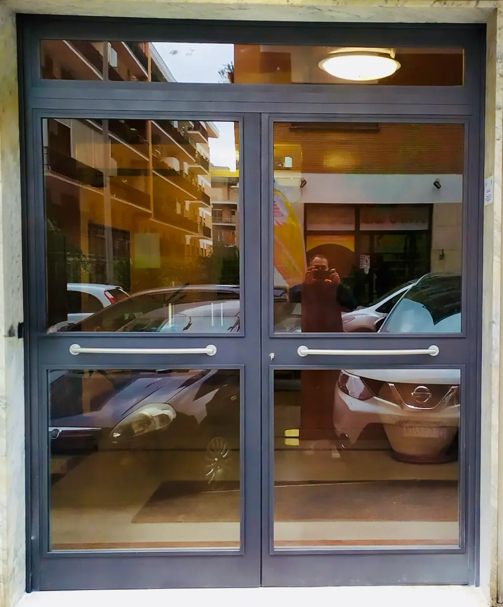 Portone d'ingresso moderno in acciaio e vetro per condomini Roma